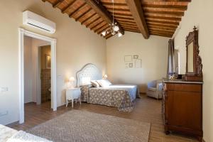 um quarto com uma cama e uma cómoda num quarto em Gorgeous Villa Peccioli, with private pool, AC, Wifi em Legoli