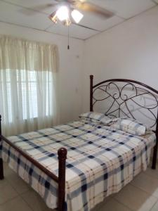 1 dormitorio con 1 cama con manta a cuadros en Coronado coronado en Playa Coronado