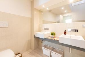 a bathroom with two sinks and a mirror at Realkasa Urbana Luxury Apt in Bologna +14 photos