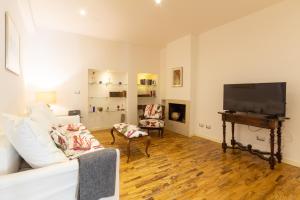 a living room with a white couch and a flat screen tv at Realkasa Urbana Luxury Apt in Bologna