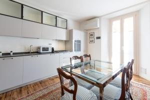 a kitchen with a glass table and chairs at Realkasa Urbana Luxury Apt in Bologna