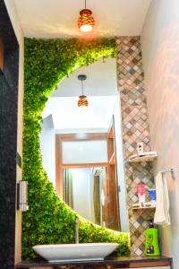 a bathroom mirror with green ivy on the wall at Bhoomika Royal Villa, Kolhapur in Kolhapur