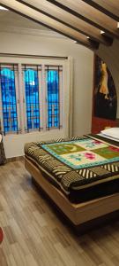 a bedroom with a large bed in a room with windows at MR staye in Ooty