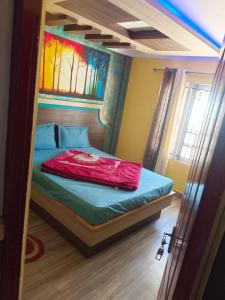 1 dormitorio con 1 cama con una pintura en la pared en MR staye, en Ooty