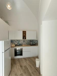 波西塔諾的住宿－Regina Margherita，厨房配有白色橱柜和冰箱。