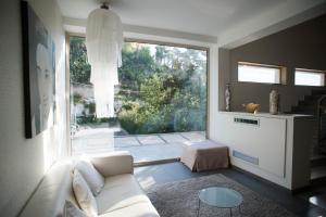 sala de estar con sofá blanco y ventana grande en FerroHotel, en Módica