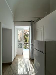 a kitchen with a refrigerator and an open door at Regina Margherita in Positano