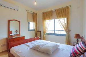 a bedroom with a bed and a mirror and a window at Villa Angelena in Droushia +27 photos