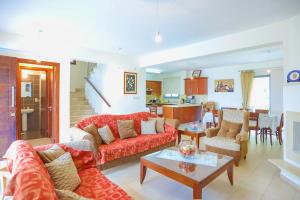 ein Wohnzimmer mit einem roten Sofa und einem Tisch in der Unterkunft Villa Angelena in Dhrousha