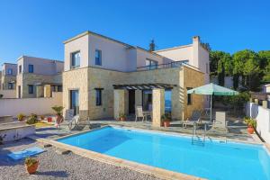 a villa with a swimming pool in front of a house at Villa Angelena in Droushia