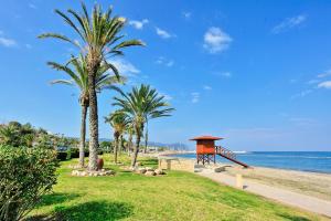una playa con palmeras y un parque infantil en Villa Angelena, en Droushia