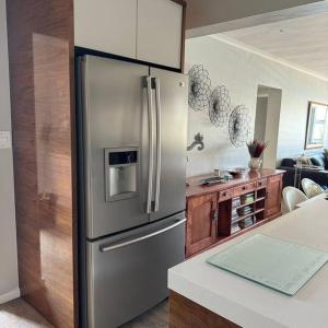 Il comprend une cuisine équipée d'un réfrigérateur en acier inoxydable. dans l'établissement Clanwilliam Waterside Villa, à Clanwilliam