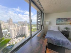 - une chambre avec un lit et une grande fenêtre dans l'établissement Bright Waikiki Studio condo, à Honolulu