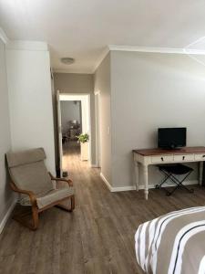 a bedroom with a bed and a desk and a chair at Clanwilliam Waterside Villa in Clanwilliam