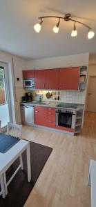 uma cozinha com armários vermelhos e uma mesa em Baabe - Insel Rügen - Ostsee - Ferienwohnung em Baabe