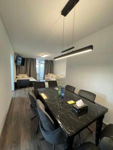 a dining room with a black table and chairs at Deluxe Apartment in Bonn