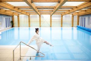 Una donna in abito bianco che balla in piscina di Wellness hotel Lihovar a Třemošnice