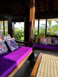 Pokój z fioletowymi poduszkami i poduszkami w obiekcie Di Kubu YR w mieście Jembrana