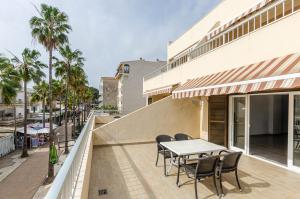 een patio met een tafel en stoelen op een balkon bij Acapulco Apartments in Can Picafort