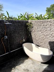 a bathroom with a bath tub and a sink at Di Kubu YR in Jembrana