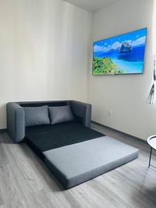 ein Sofa in einem Zimmer mit einem Bild an der Wand in der Unterkunft Modern Studio Apartment in Riga in Riga