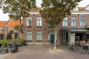 un edificio de ladrillo con una puerta verde en una calle en NEW Hello Zeeland - Vakantiehuis Markt 10 en Domburg
