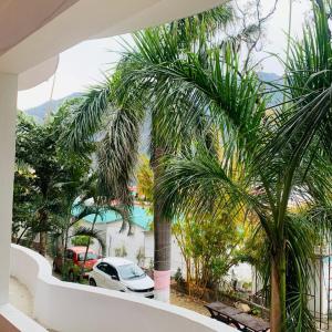 uma vista a partir da varanda de uma casa com palmeiras em The Roxxy Royal Resort em Rishikesh
