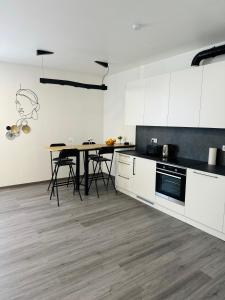 a kitchen with white cabinets and a table and chairs at Modern Studio Apartment in Riga in Rīga
