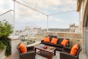 エルサレムにあるOld City Luxury Duplex with Rooftop by FeelHomeのバルコニー(ソファ、テーブル、オレンジの枕付)