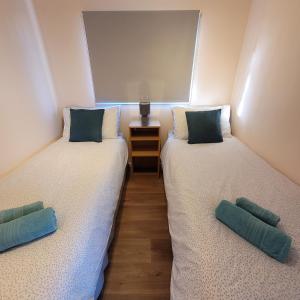 two twin beds in a room with a window at Stonesthrow in Stalham