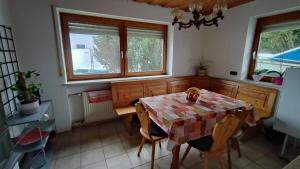 cocina con mesa, sillas y ventanas en Monteursunterkunft Egenhofen, en Egenhofen
