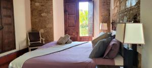 1 dormitorio con 1 cama con 2 lámparas y una ventana en Palacio de los Angulo casa histórica en el centro de Córdoba en Córdoba