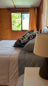 ein Schlafzimmer mit einem großen Bett und einem Fenster in der Unterkunft Cabañas Mahatua in Hanga Roa