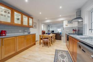a large kitchen with wooden cabinets and a table at Harbour Hideaway St Monans in Saint Monance