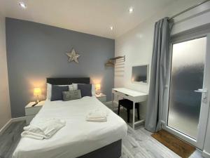 a bedroom with a bed with a desk and a window at Reads Court Holiday Apartments - Blackpool Resort Collection in Blackpool