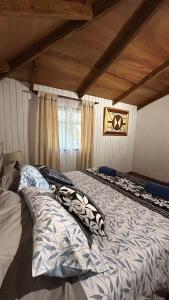 a large bed sitting in a room with aamed at Cabañas Mahatua in Hanga Roa