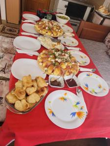 una larga mesa roja con platos de comida. en Apartmani Božana Vojinović, en Žabljak