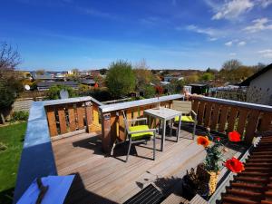 a balcony with a table and chairs on a deck at Rügenblick in Lubmin