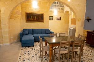 a living room with a blue couch and a table at Surwig Gozitan Villa & Pool - Happy Rentals in Kerċem