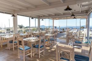a restaurant with tables and chairs and windows at Caldera Romantica in Akrotiri