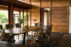 a dining room with a wooden table and chairs at July Villas in Canggu