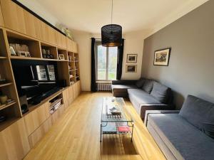 uma sala de estar com um sofá e uma mesa de centro em Demeure de prestige au cœur de Rueil-Malmaison em Rueil-Malmaison