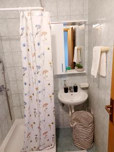 a bathroom with a shower curtain and a sink at Apartmani Leženić Dada in Neum