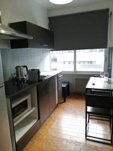 una cucina con mobili neri e un forno a piano cottura di Annecy Dream Appart ad Annecy