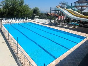 a large swimming pool with a slide in the background at Sapanca Aqua Wellness Spa Hotel in Sapanca