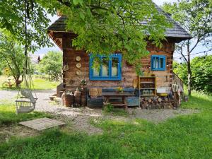a small log cabin with a blue window and a bench at Big family Apartment in Breb's Cosy Barn in Breb