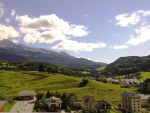 miasto z zielonym polem i górami w tle w obiekcie Appartement 2P plein sud, centre Villard de Lans, balcon, parking, pour 6 pers - FR-1-689-34 w mieście Villard-de-Lans