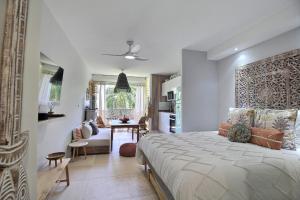 een slaapkamer met een groot bed en een eetkamer bij La Suite Serendipity piscine et plage in Saint-François