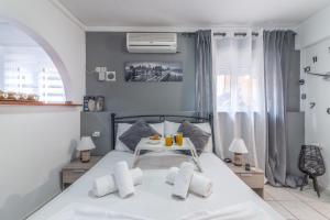 een slaapkamer met een wit bed en een raam bij Oasis Studios in the City Centre in Heraklion