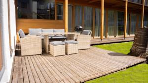 una terrazza in legno con tavolo e sedie in vimini di Eva Apartments - Patscherkofel a Innsbruck